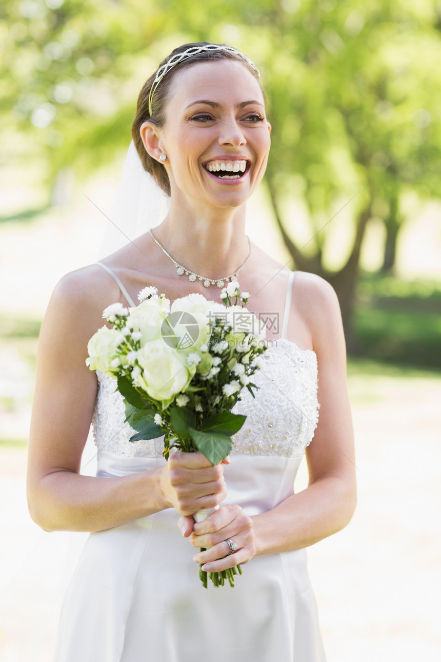 新娘在花园大笑时拿着花束图片