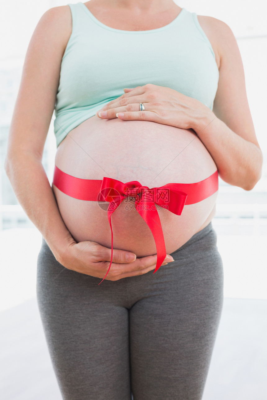 孕妇腹围着红弓站立的孕妇图片