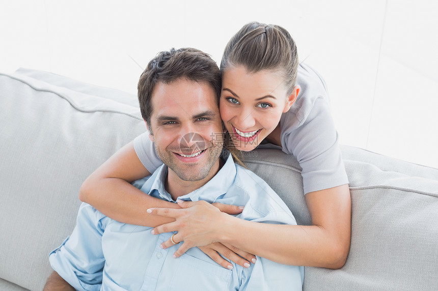 快乐的一对情侣在镜头前微笑夫妻闲暇家庭沙发客厅男人公寓男性住所感情图片