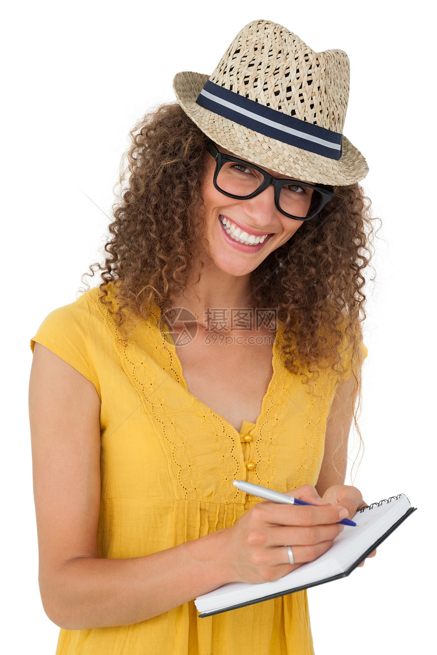 以笔记本写作的快乐年轻女子笑声棕色眼镜女士女性头发帽子记事本卷发微笑图片