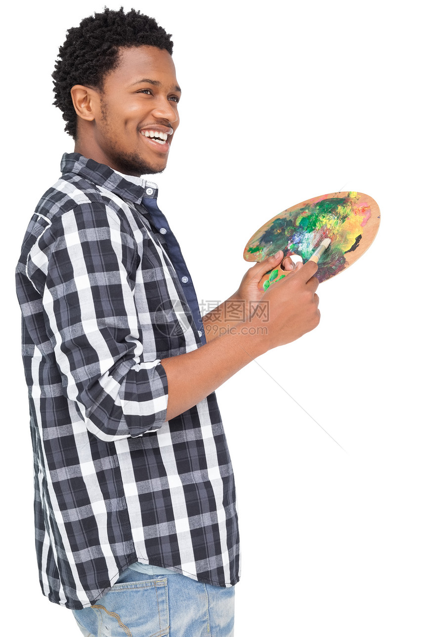 年轻男画家配调色盘的侧面视图图片
