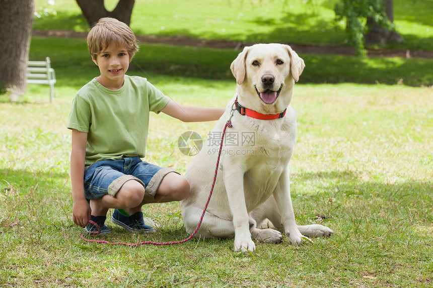 在公园养宠物狗的男孩图片