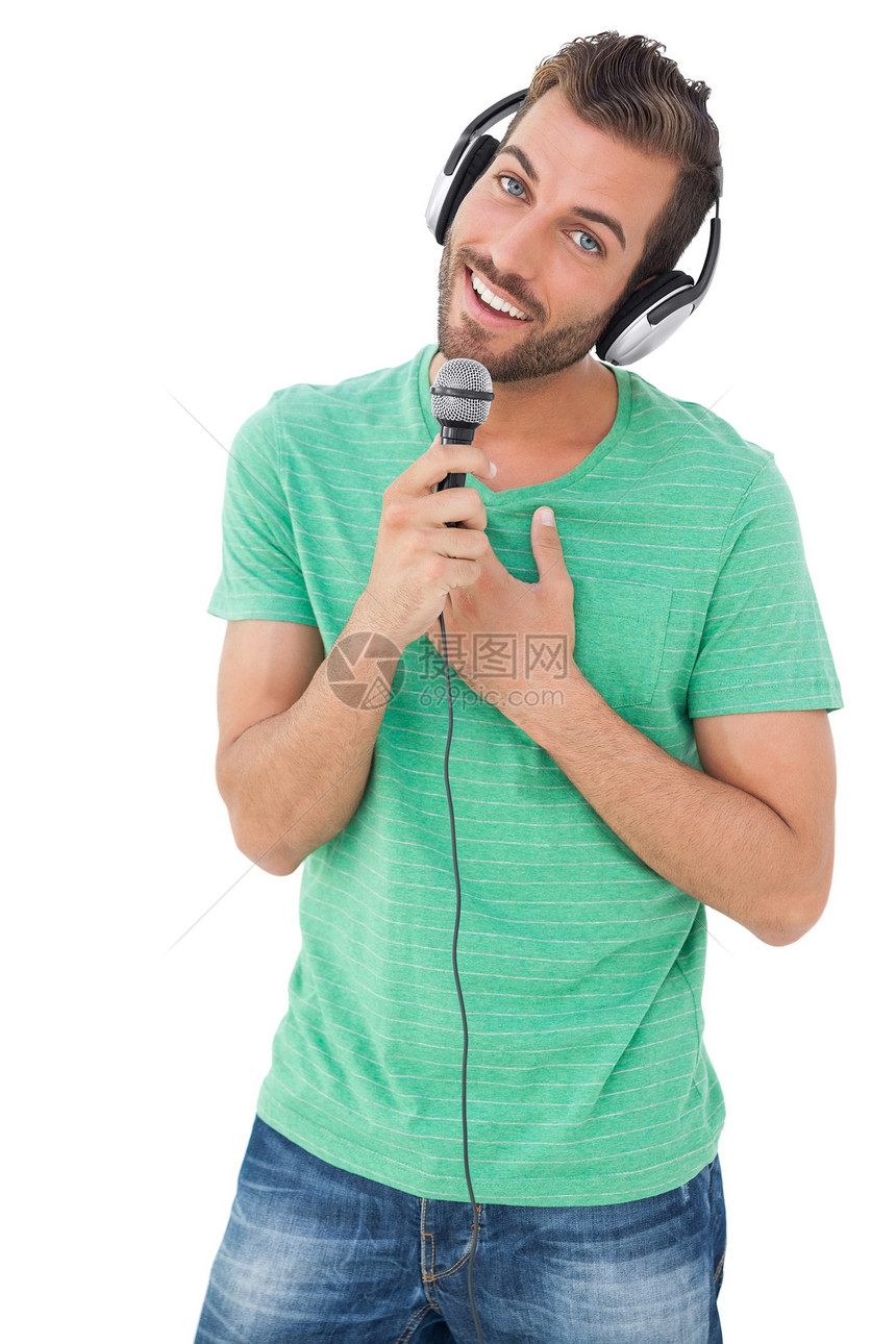 一个年轻人的肖像 歌唱到麦克风男性牛仔布幸福享受男人音乐青年闲暇绿色爱好图片