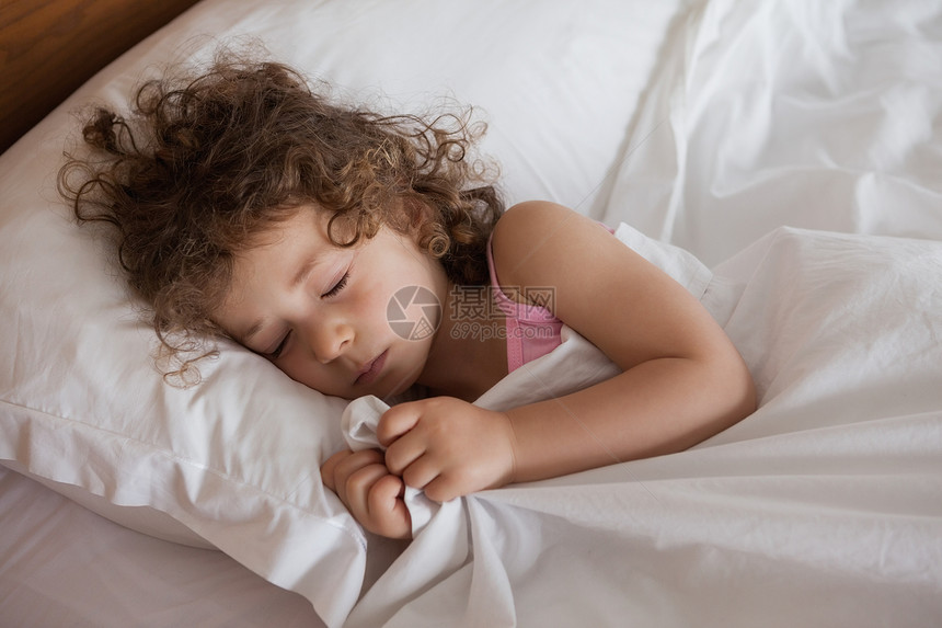 一个睡在床上的可爱女孩的近身坐垫房子闲暇童年睡眠女性羽绒被卧室枕头公寓图片