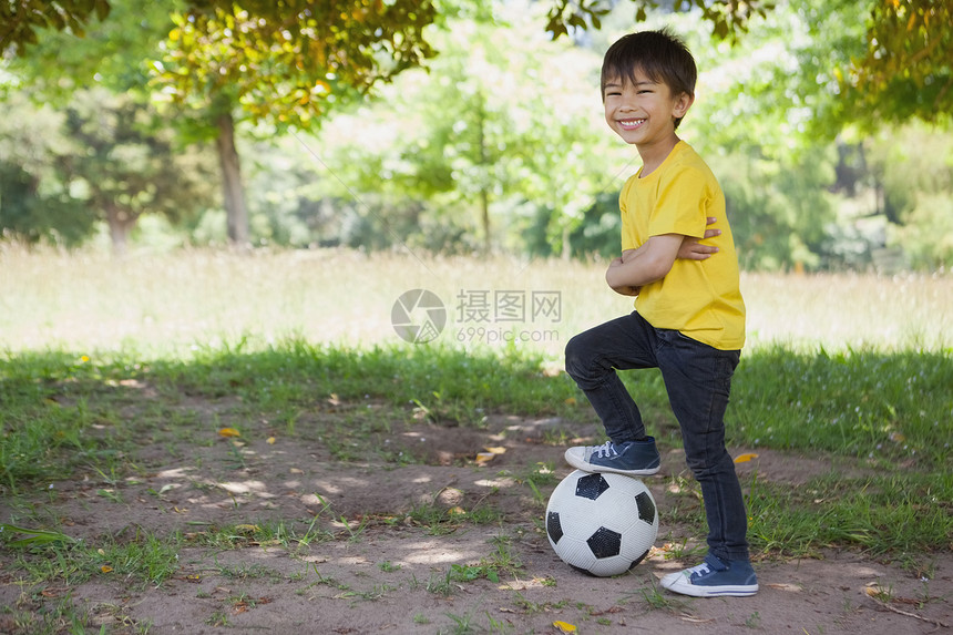 小可爱男孩 足球在公园微笑童年牛仔裤运动男生双手草地牛仔布男性绿色图片