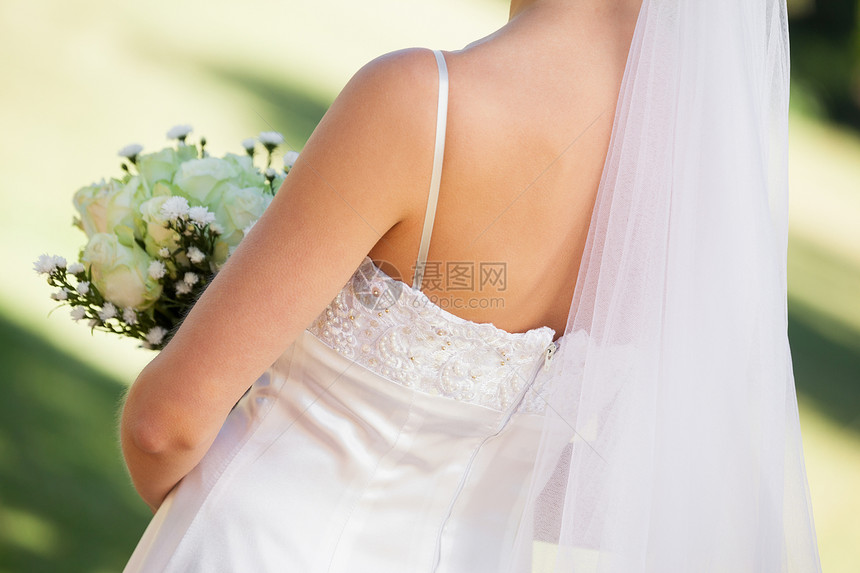 年轻美丽新娘的中间部分带花束图片