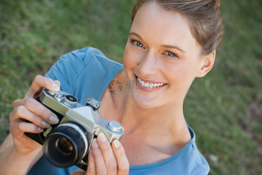 公园中美丽的女摄影师技术快乐幸福摄影女性女士草地绿地爱好微笑图片