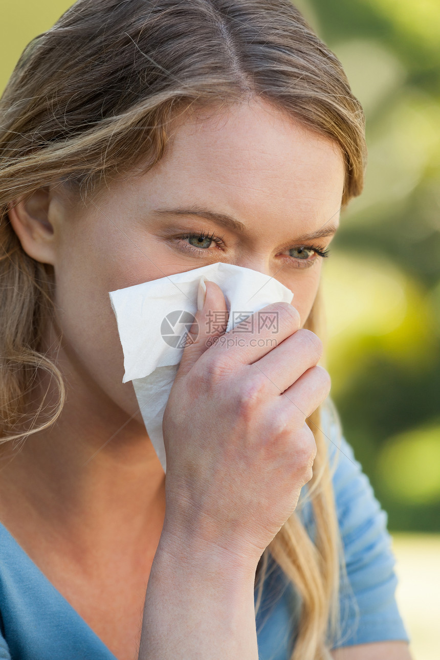 妇女在公园用纸纸打鼻涕花园女士感染鼻子流感组织女性过敏喷嚏疾病图片