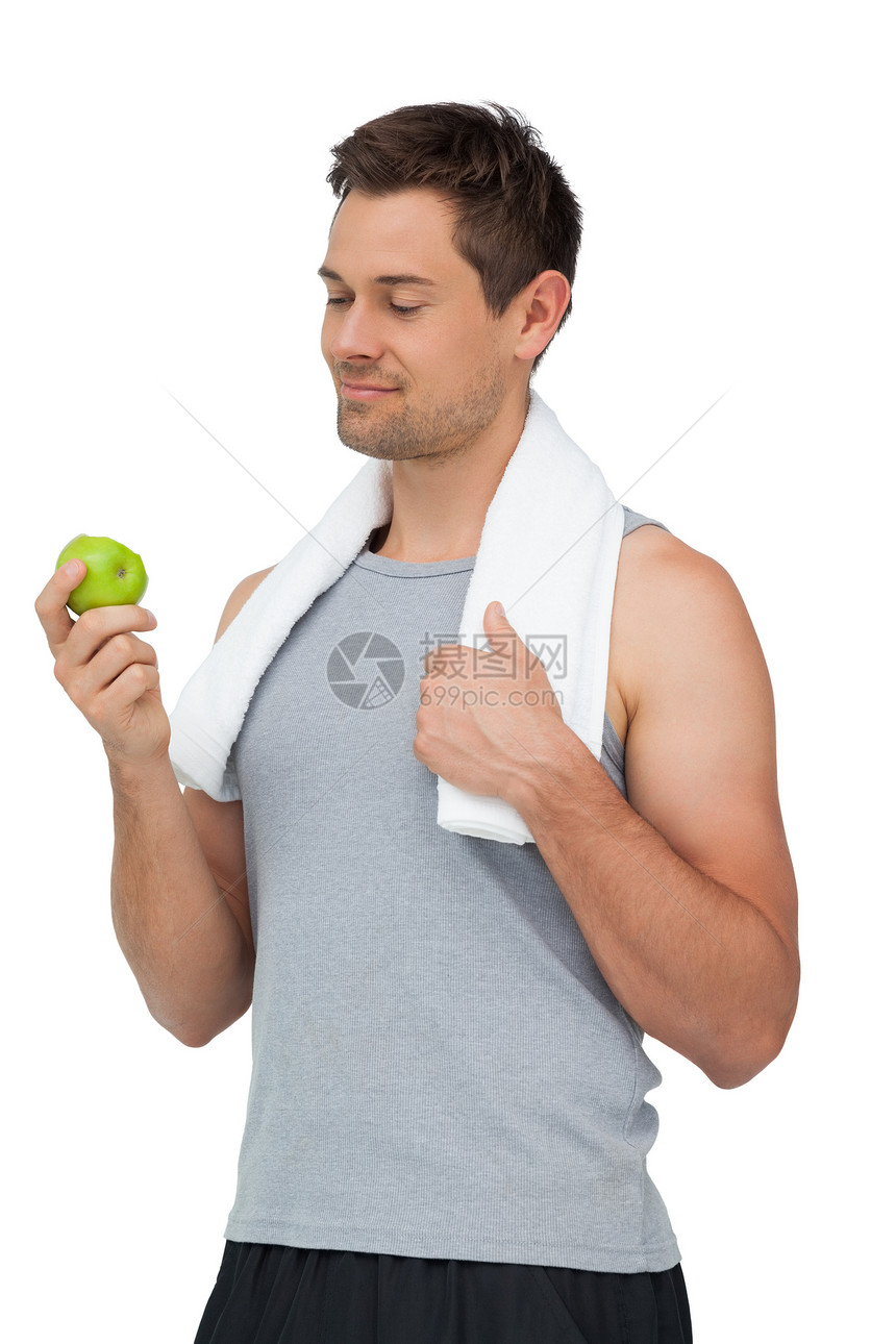 一个微笑的 与苹果相配的年轻人的肖像水果肌肉身体男性绿色闲暇运动员短裤调子竞技图片