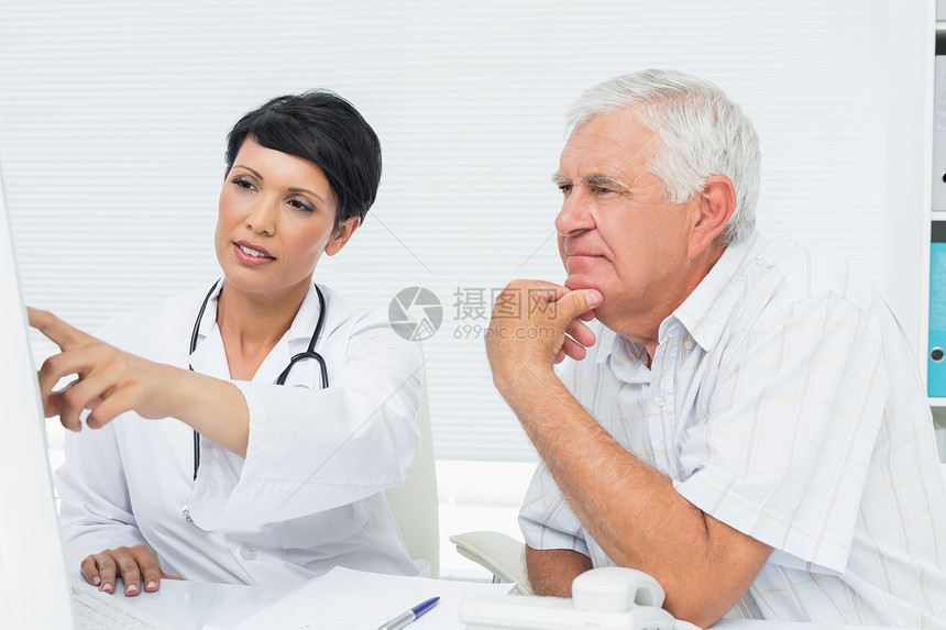 医生和男性病人在计算机上阅读报告的报告治疗女士诊所人员成人退休男人卫生电脑保健图片