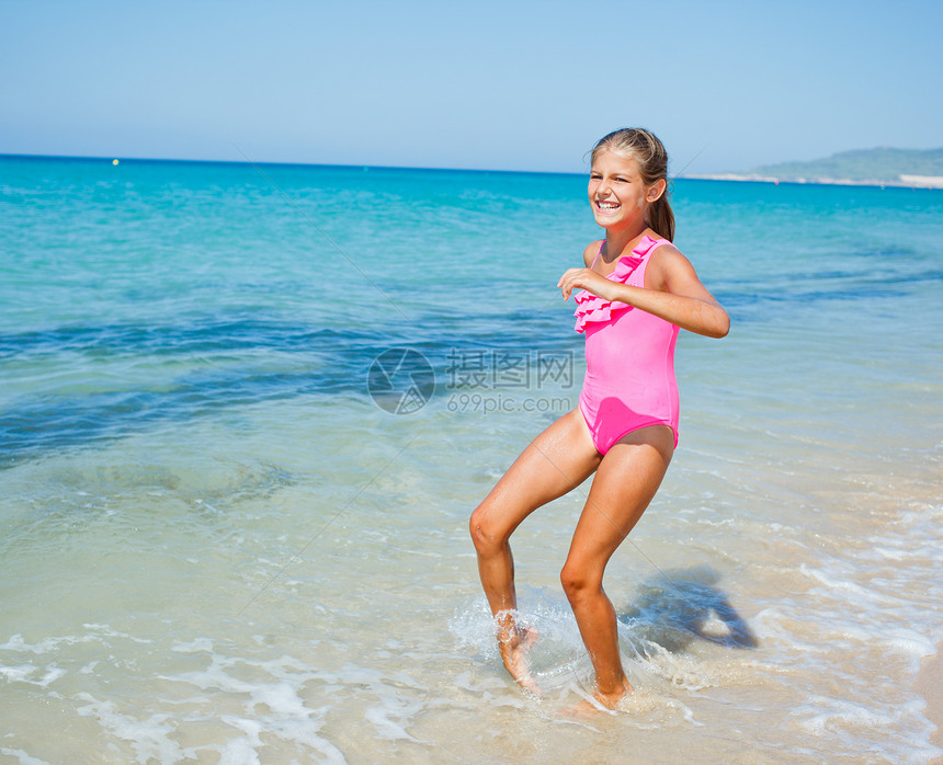 海滩上可爱的女孩海洋游泳衣海岸幸福孩子热带太阳海岸线支撑跑步图片