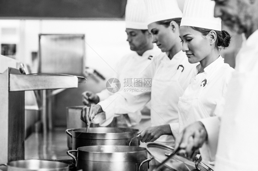 在炉灶工作的一排厨师团队餐厅专注女士同事炉顶厨艺制服女性伙伴图片