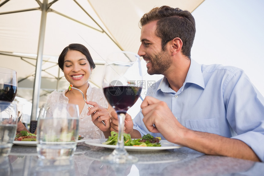 晚饭时快乐的一对情侣闲暇混血微笑女性咖啡店男人露台沙拉男性餐厅图片