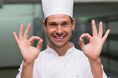 开心的厨师在相机上签好牌餐厅商业工作酒店男人大楼制服职员职业双手背景