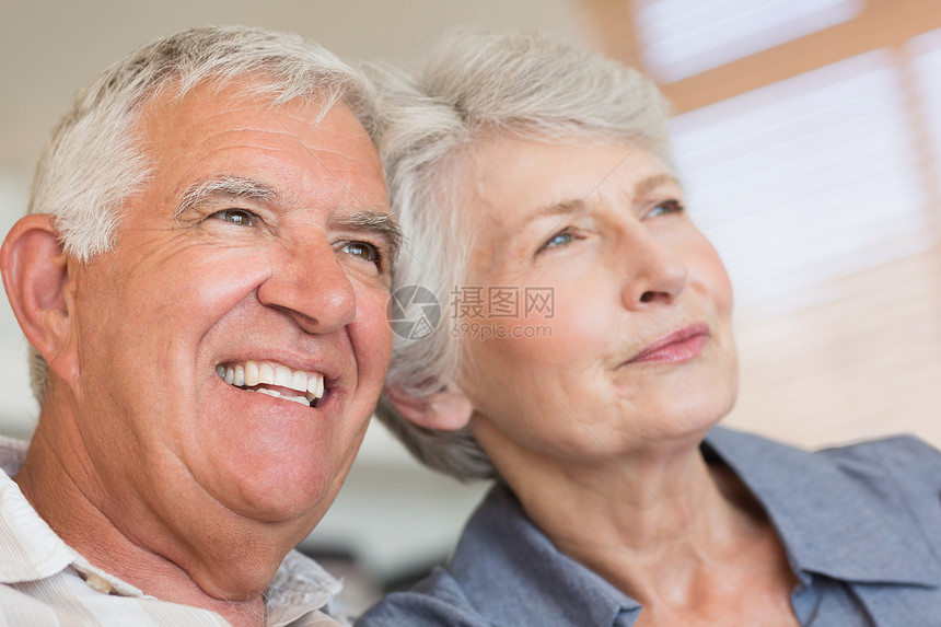 坐在沙发上微笑的老夫妇房子男人退休闲暇长椅感情客厅男性快乐公寓图片