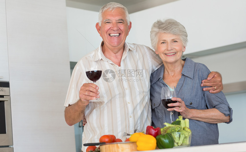 准备一顿饭和喝红酒的老夫妇微笑退休健康饮食房子男人蔬菜厨房切菜板亲密感夫妻闲暇图片