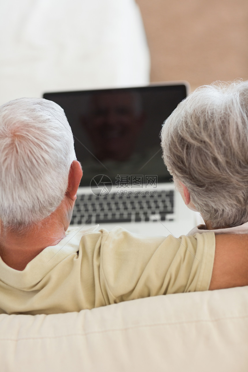一起用笔记本电脑的老幸福情侣男性拥抱女士沙发成人闲暇老年头发女性房子图片