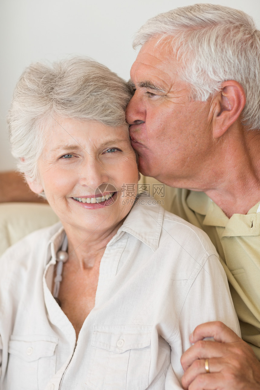 高龄情侣在沙发上一起放松闲暇男人成人公寓老年住所女士退休快乐拥抱图片
