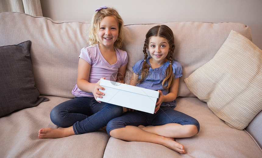 两个女孩坐在沙发上带着礼品盒的年轻女孩图片