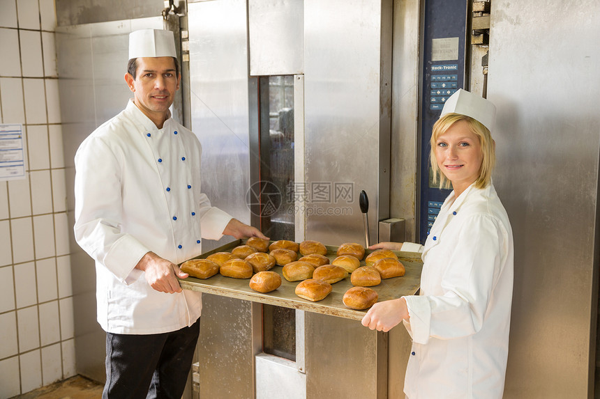 面包店或面包房里有面包片的面包师生产制造业烹饪糕点黄油糖果商糖果美食食物厨房图片