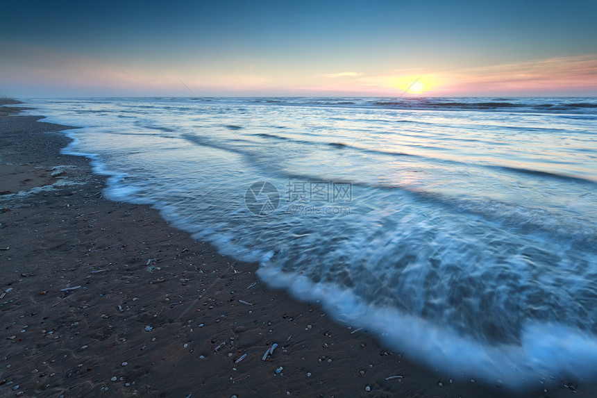 北海沙滩上温暖的日落阳光风景天空海浪太阳蓝色海滩假期金子低潮图片