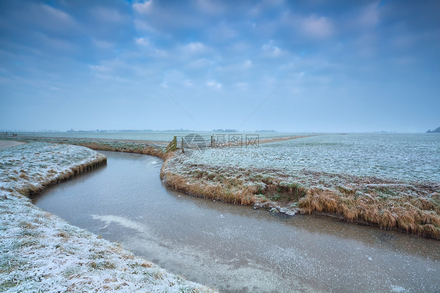 荷兰农田上的冷冻运河图片