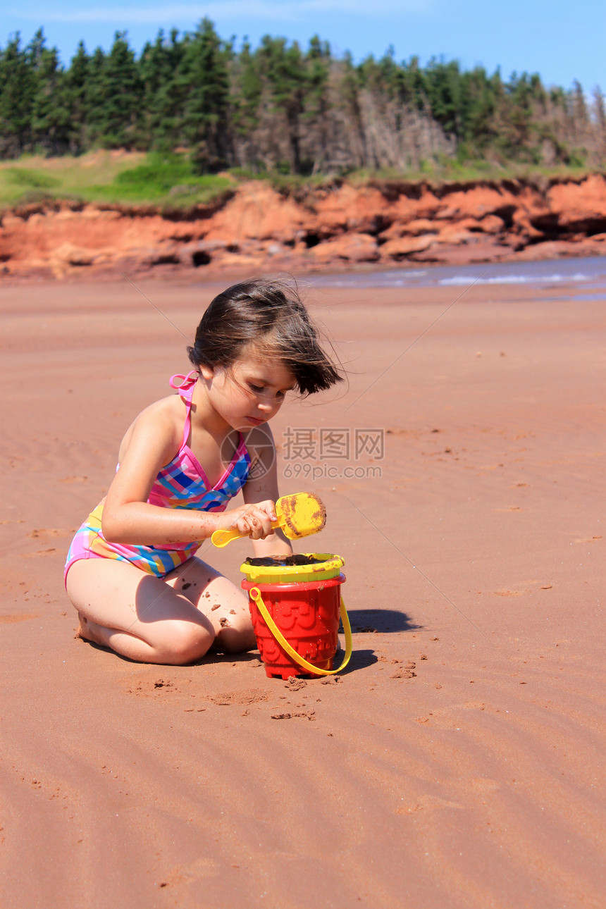 PEI 海滩上的小女孩女性海岸线海洋旅行海岸玩具晴天乐趣红色旅游图片