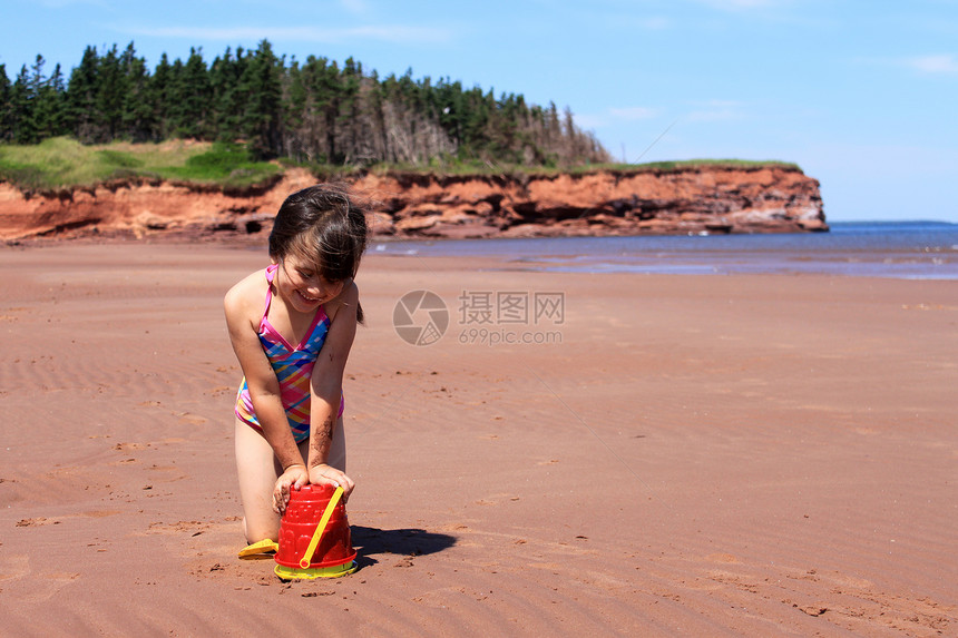 PEI 海滩上的小女孩红色玩具女性假期晴天孩子海洋旅游风景乐趣图片