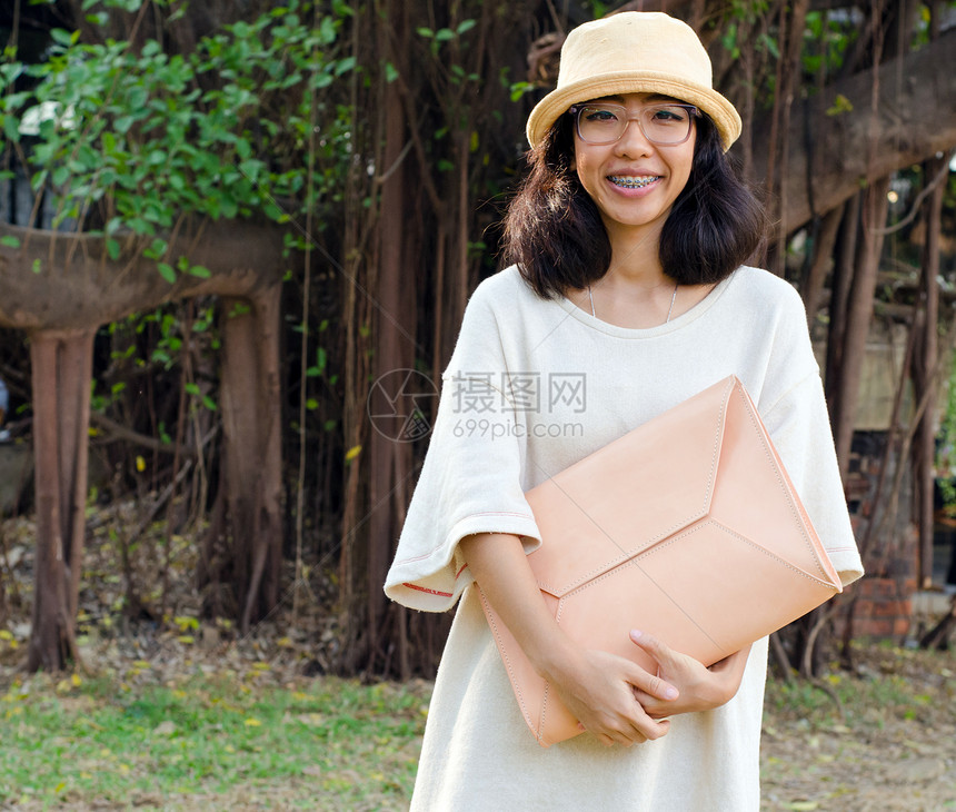 带手提包的年轻时装女孩成人购物旅行皮革衣服城市帆布奢华时尚奶油图片