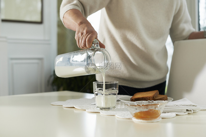 高龄妇女用牛奶吃早餐的肖像玻璃饮食退休豆浆杯子女士水壶奶制品窗户女性图片