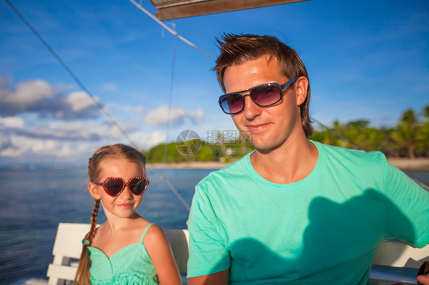 可爱的小女孩和年轻爸爸 在船上航行时放松了下来图片