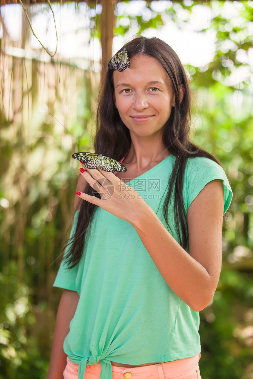 在自然花园里 带着蝴蝶的年轻女人图片