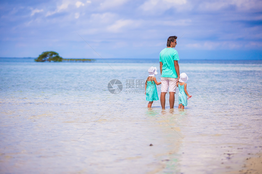 年轻父亲和他的两个可爱女儿 在异国度假的节假日爸爸海岸男人享受幸福父母乐趣女孩海滩海岸线图片