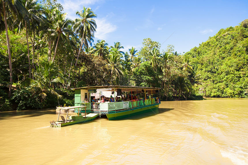 与游客在博霍尔洛博克丛林河上搭乘的外游游船航程椰子森林棕榈血管热带河景情调旅行荒野图片