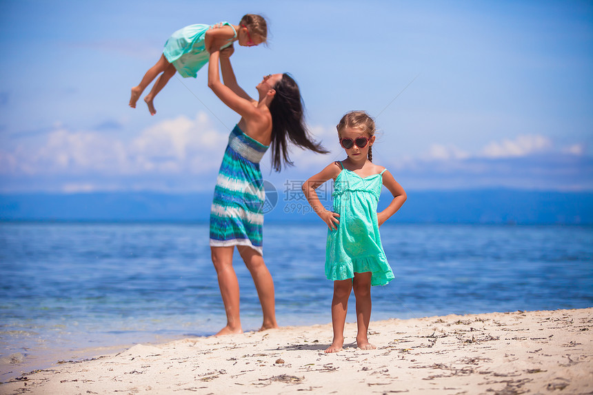 年轻快乐的母亲和可爱的女儿们 在阳光明媚的天气在异国海滩玩得开心沙漠婴儿女儿海滨妈妈热带女孩孩子女士假期图片