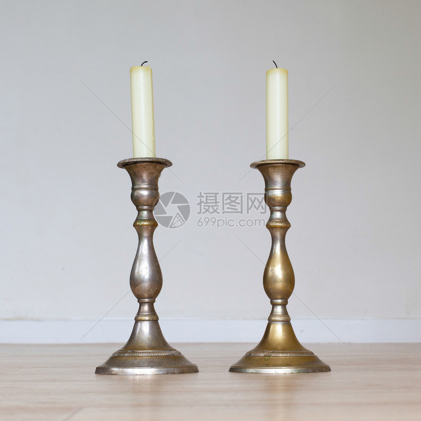 在木制桌上烧蜡烛传统烛光火焰桌子白色青铜拇指烛台烧伤季节图片