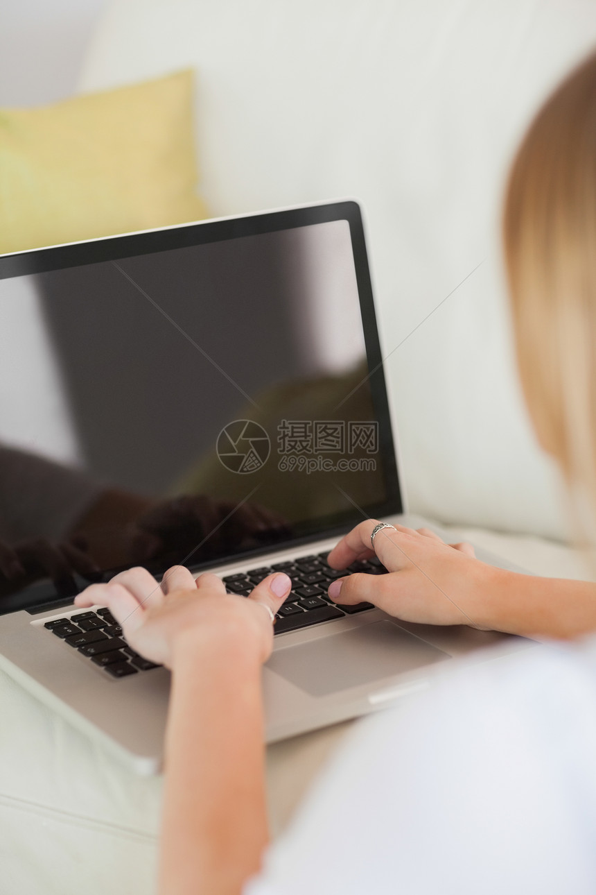 金发女人在笔记本电脑上打字金发女郎长椅住所女性沙发长发浅色头发地面客厅图片
