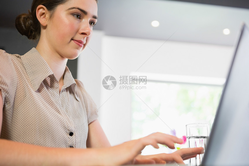 近距离观察在她笔记本电脑上工作的女商务人士图片
