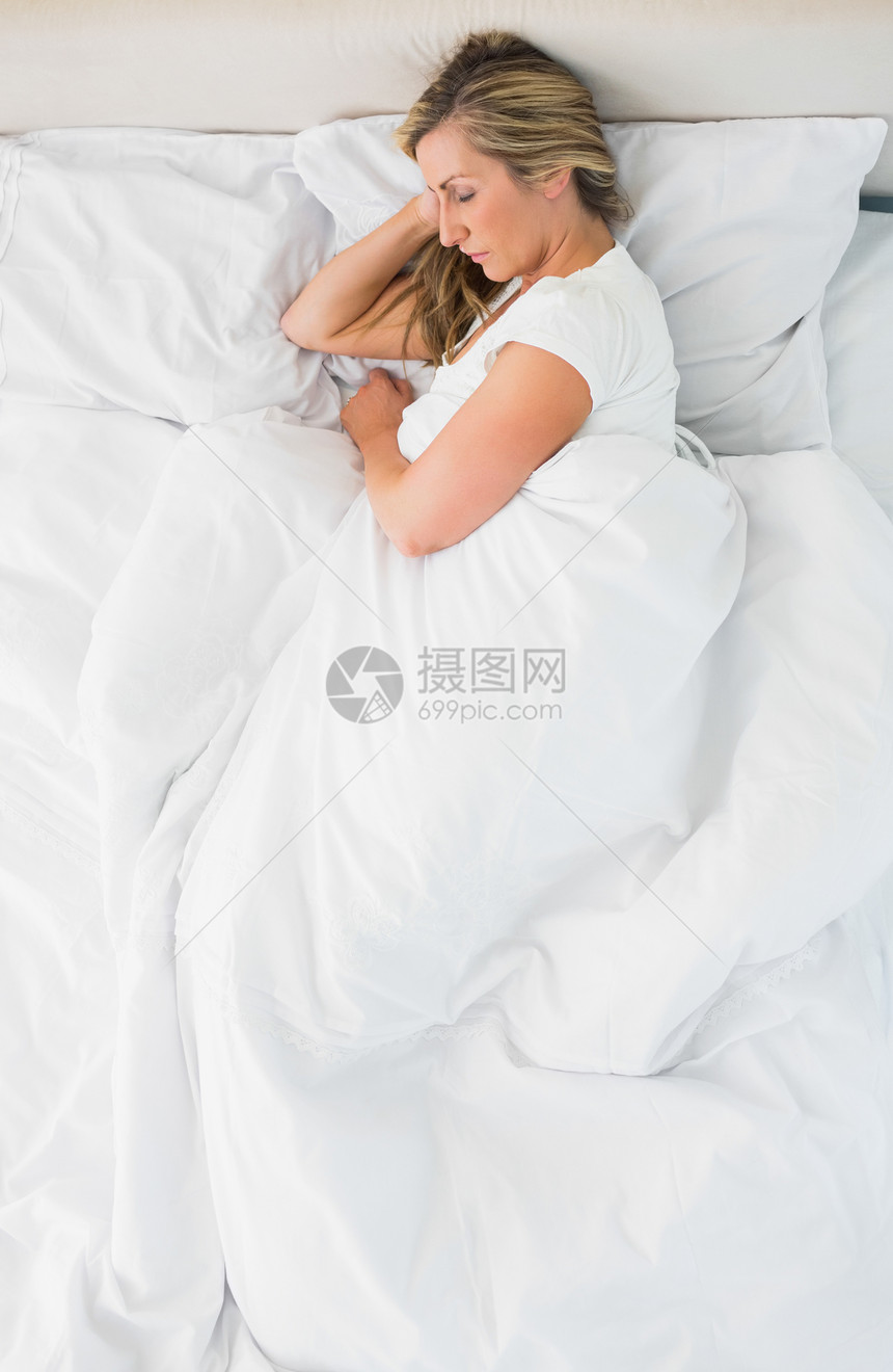 睡着的女人躺在床上金发女郎住所浅色卧室枕头棉被房子家庭头发长发图片