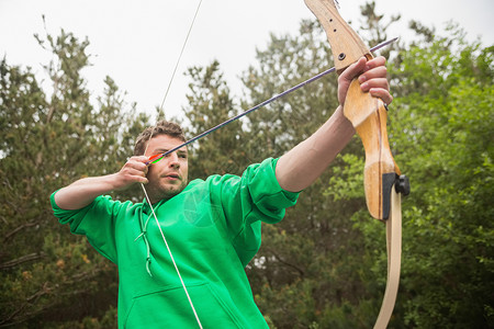 射箭场集中力的人练射箭农村竞技男性男人绿色牵引活动专注运动服娱乐背景
