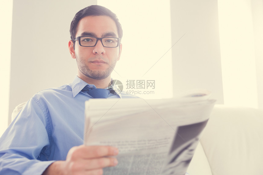 低落的男人看着相机 拿着报纸 (笑声)图片