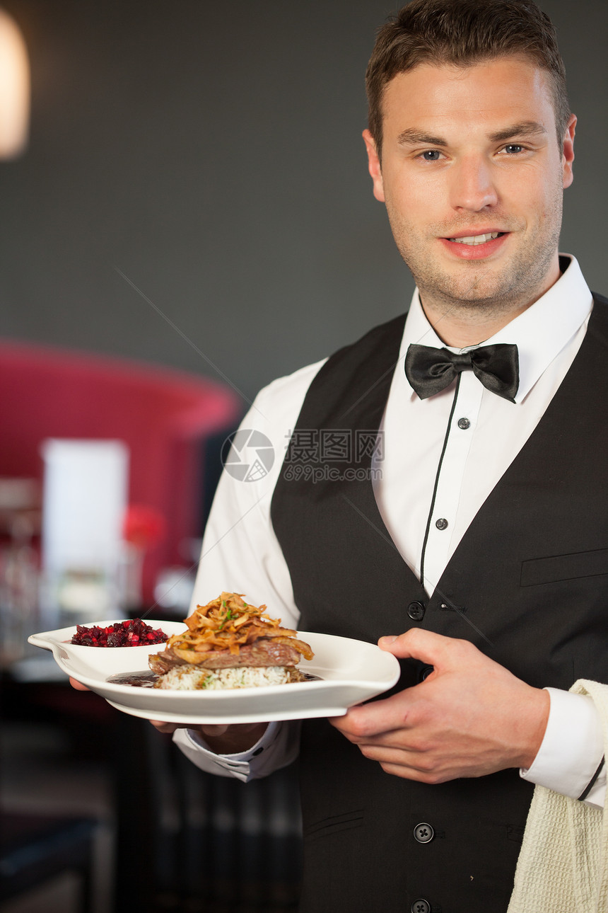英俊的侍者 为美味的鸭子菜服务图片