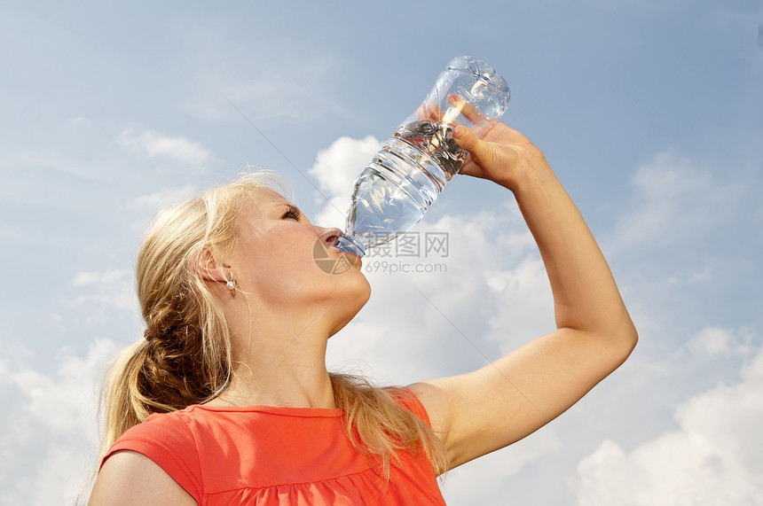 妇女饮用水金发运动红色口渴金发女郎蓝色矿泉水瓶子天空休息图片
