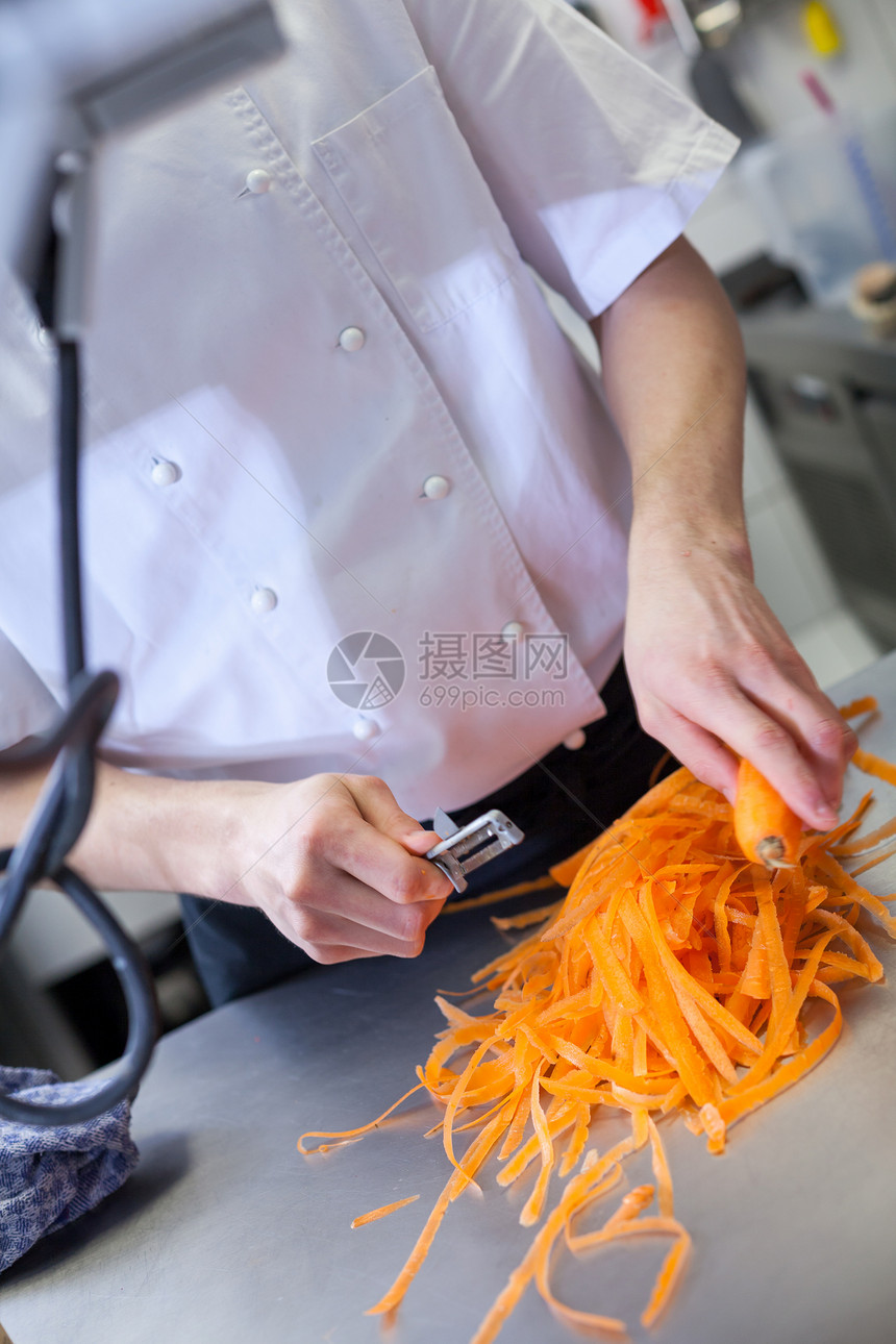 大厨穿制服 准备新鲜胡萝卜警棍男性厨师男人酒店柜台厨房根菜萝卜餐饮业菜板图片