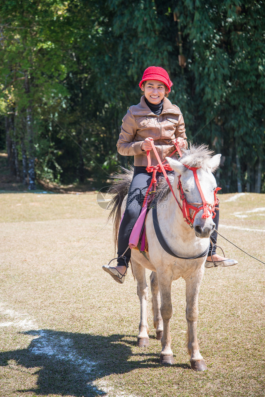 亚洲骑马的妇女友谊马术场地运动帽子旅行女孩动物黑发牛仔图片