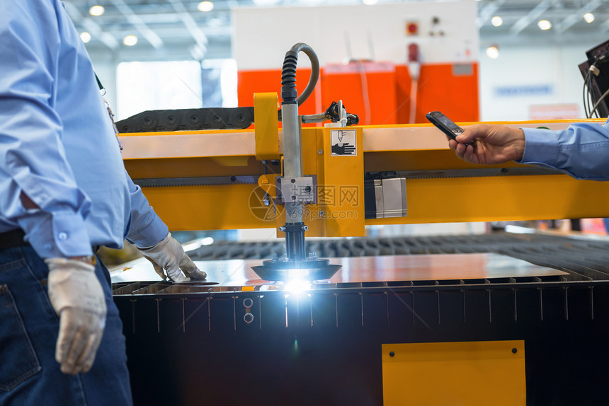 在工厂中切割钢铁的机器商业工程工具男人机械激光压力金工生产技术图片