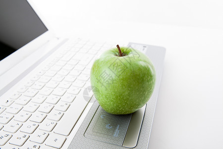 笔记本电脑键盘上的绿苹果办公室互联网水果喘息静物工作白色购物桌子绿色背景图片