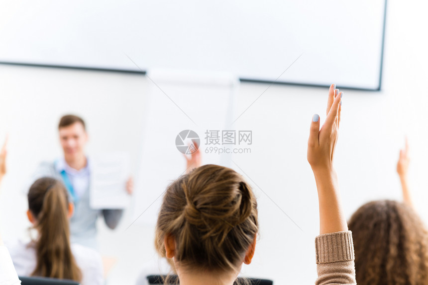 女性在班级中举起的手成人教育注意力桌子教育家同学学习大学中学女士图片
