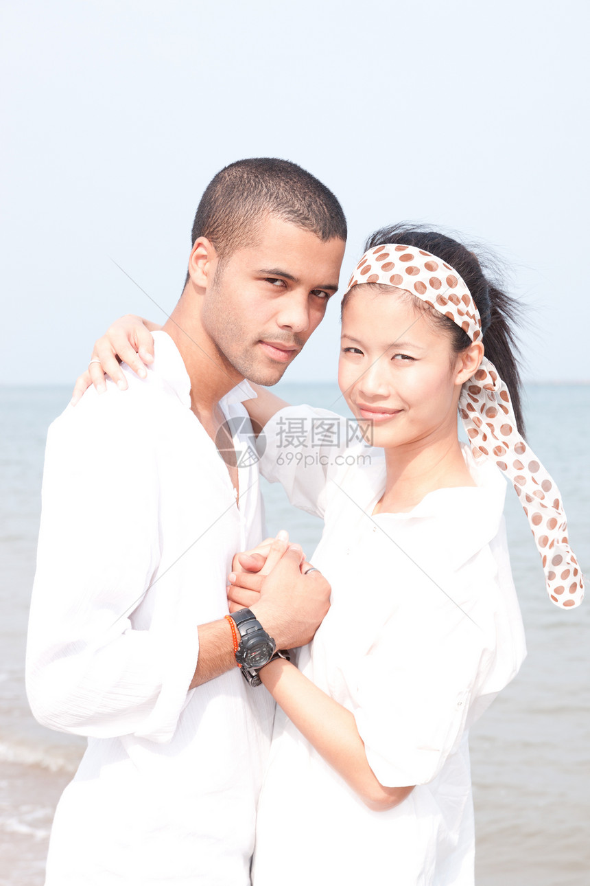 非洲男人和亚洲女人在海滩上的爱人小猪夫妻男性女孩海洋蓝色乐趣女性女士感情图片