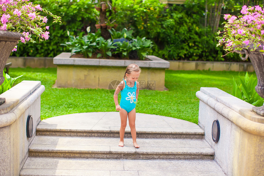 在豪华度假村露天泳池附近的小女孩青年女儿快乐旅游女孩蓝色童年孩子酒店喜悦图片